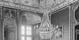 Historical photograph of the northwest corner of the Red Room, with stucco, mirror, and chandelier, Bruchsal Palace before its destruction.