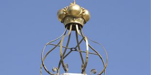 Peak of the roof with a golden crown at Bruchsal Palace.