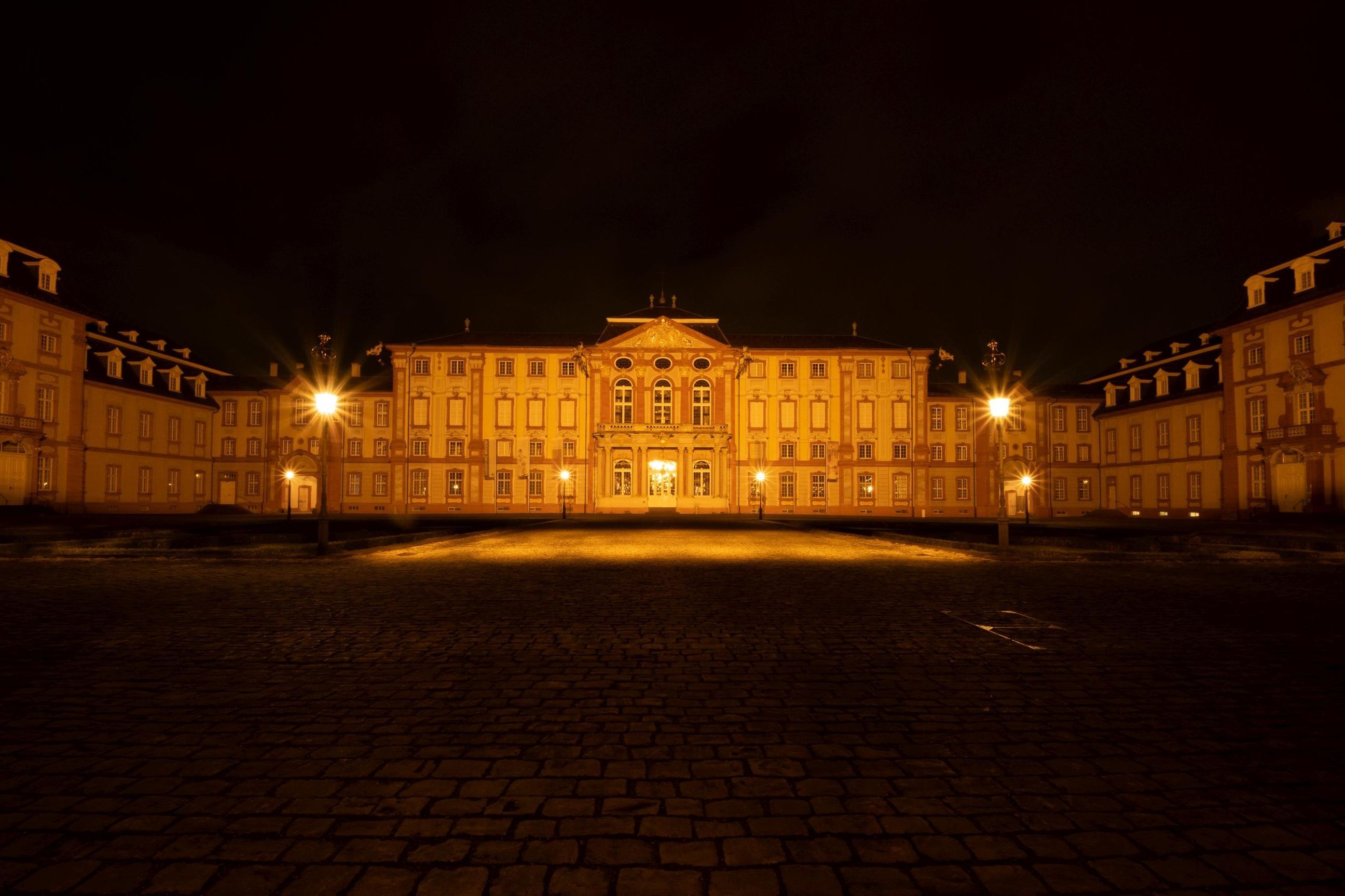 Blick auf das beleuchtete Schloss Bruchsal bei Nacht