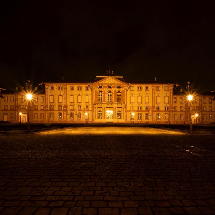 Blick auf das beleuchtete Schloss Bruchsal bei Nacht