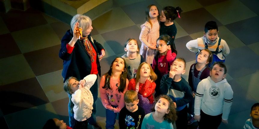 Schloss Bruchsal, Gruppe staunender Kinder, die nach oben schauen, mit Begleitperson 