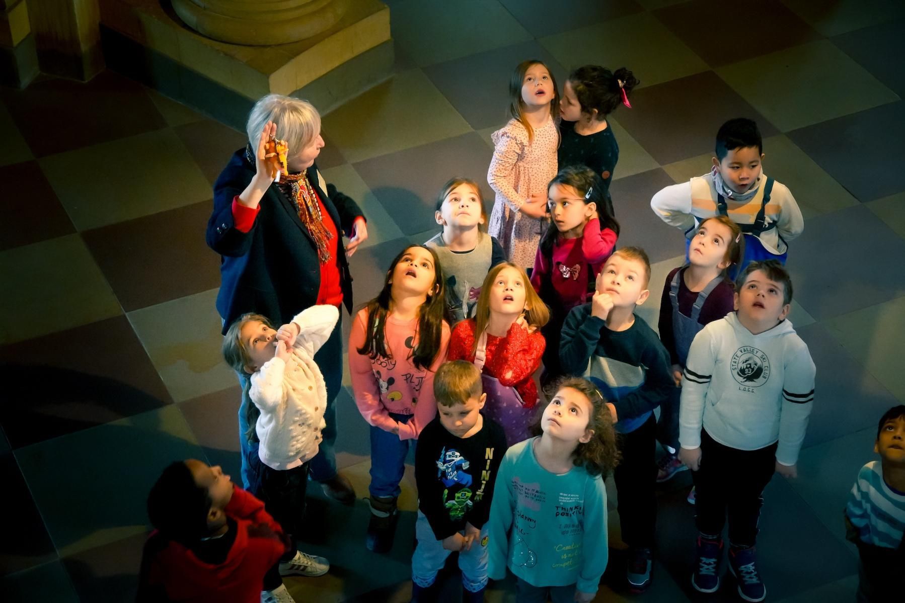 Schloss Bruchsal, Gruppe staunender Kinder, die nach oben schauen, mit Begleitperson 
